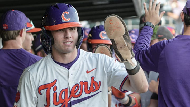 Clemson catcher Nate Savoie (99) is congratulated by teammates after scoring during the bottom of the first inning at Doug Kingsmore Stadium in Clemson, S.C. Tuesday, April 21, 2026.