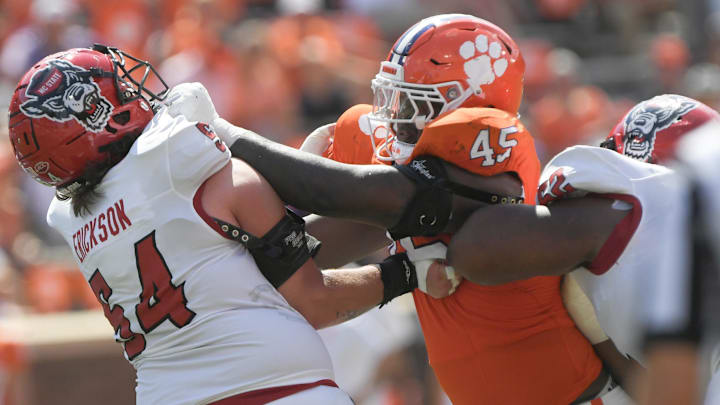 Sep 21, 2024; Clemson, South Carolina, USA; Clemson Tigers defensive lineman Vic Burley (45) and North Carolina State offensive lineman Rico Jackson (64) battle during the third quarter at Memorial Stadium. 