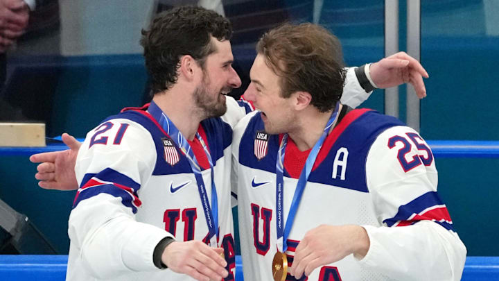 Dylan Larkin and Long Beach native Charlie McAvoy of the USA men's hockey team celebrates after winning against Canada in the gold medal game during the 2026 Milano Cortina Olympic Winter Games at Milano Santagiulia Ice Hockey Arena.