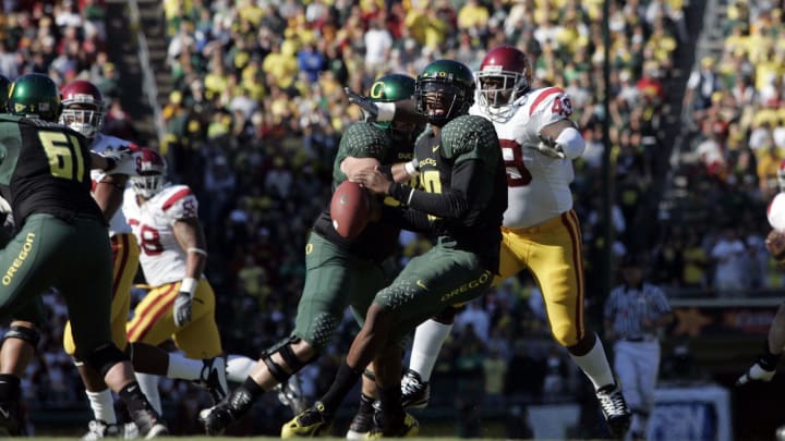 Oct 27, 2007; Eugene, OR, USA; Oregon quarterback Dennis Dixon (10) evades a tackle by USC defensive tackle Sedrick Ellis (49) in the first quarter of Oregon's 24-17 victory over USC at Autzen Stadium.
