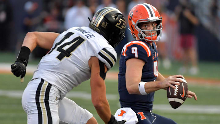Oct 12, 2024; Champaign, Illinois, USA;  Illinois Fighting Illini quarterback Luke Altmyer (9) eludes Purdue Boilermakers linebacker Yanni Karlaftis (14) in the second half at Memorial Stadium. Mandatory Credit: Ron Johnson-Imagn Images