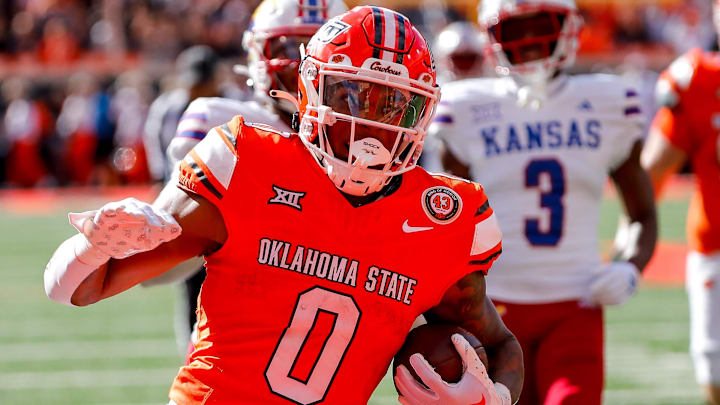 Oct 14, 2023; Stillwater, Oklahoma, USA; Oklahoma State's Ollie Gordon II (0) runs the ball in the second quarter for a touchdown against the Kansas Jayhawks at Boone Pickens Stadium. Mandatory Credit: Nathan J. Fish-Imagn Images
