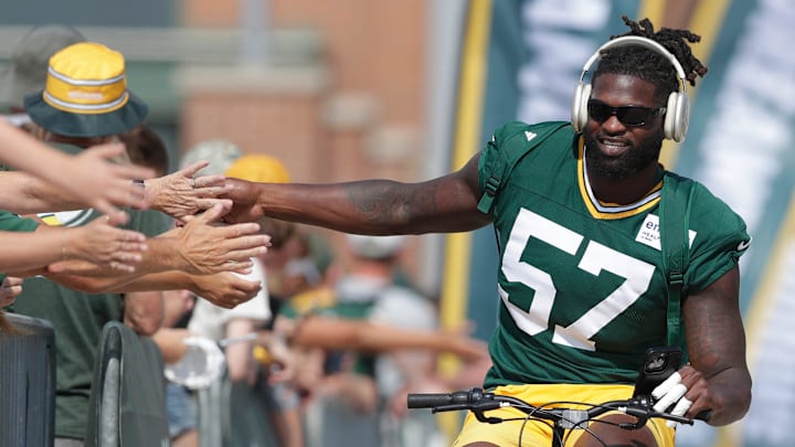 Green Bay Packers defensive lineman Brenton Cox Jr. slaps hands with fans on the way to practice at trainng camp.
