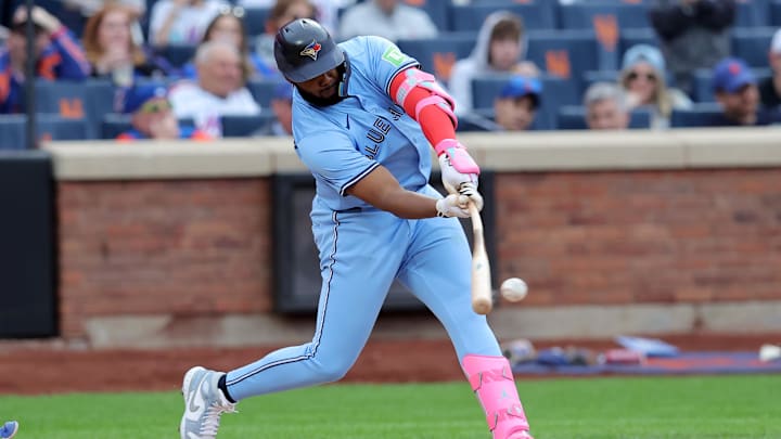 Apr 4, 2025; New York City, New York, USA; Toronto Blue Jays first baseman Vladimir Guerrero Jr. (27) hits a single during the eighth inning against the New York Mets at Citi Field. Mandatory Credit: Brad Penner-Imagn Images