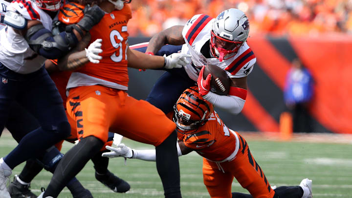 Sep 8, 2024; Cincinnati, Ohio, USA; New England Patriots running back Antonio Gibson (4) runs the ball as Cincinnati Bengals cornerback Mike Hilton (21) makes the tackle during the third quarter at Paycor Stadium. Mandatory Credit: Joseph Maiorana-Imagn Images
