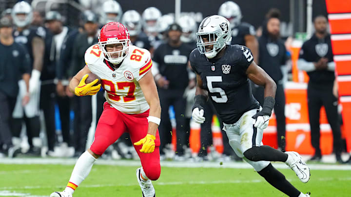 Oct 27, 2024; Paradise, Nevada, USA; Kansas City Chiefs tight end Travis Kelce (87) looks to evade the tackle of Las Vegas Raiders linebacker Divine Deablo (5) during the first quarter at Allegiant Stadium. Mandatory Credit: Stephen R. Sylvanie-Imagn Images