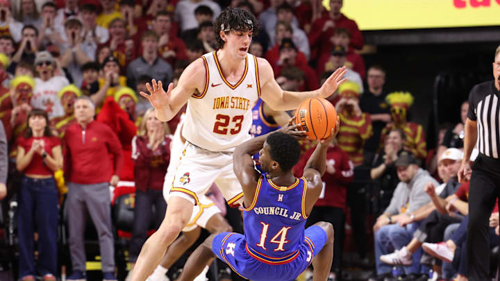 Feb 14, 2026; Ames, Iowa, USA; Iowa State Cyclones forward Blake Buchanan (23) defends Kansas Jayhawks guard Melvin Council Jr. (14) during the first half at James H. Hilton Coliseum. Mandatory Credit: Reese Strickland-Imagn Images