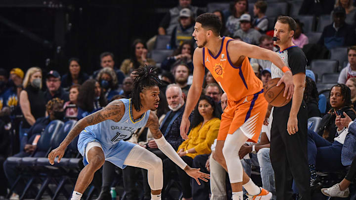Phoenix Suns guard Devin Booker (1) handles the ball against Memphis Grizzlies guard Ja Morant (12) during the first half  at FedExForum. Mandatory Credit: Justin Ford-Imagn Images