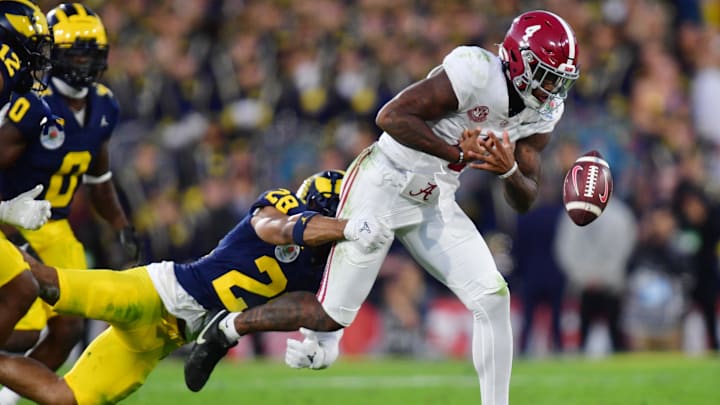 Michigan Wolverines defensive back Quinten Johnson (28) forces a fumble by Jalen Milroe (4)
