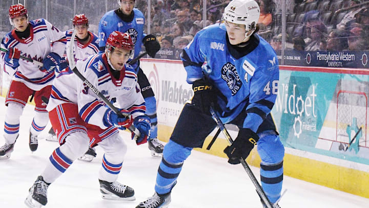Erie Otters defenseman Matthew Schaefer, right, controls the puck against the Kitchener Rangers at Erie Insurance Arena in Erie on Nov. 23, 2024.
