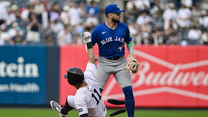 Sep 6, 2025; Bronx, New York, USA; New York Yankees shortstop Anthony Volpe (11) slides into second base with a double as Toronto Blue Jays shortstop Isiah Kiner-Falefa (7) awaits the throw during the sixth inning at Yankee Stadium. Mandatory Credit: John Jones-Imagn Images
