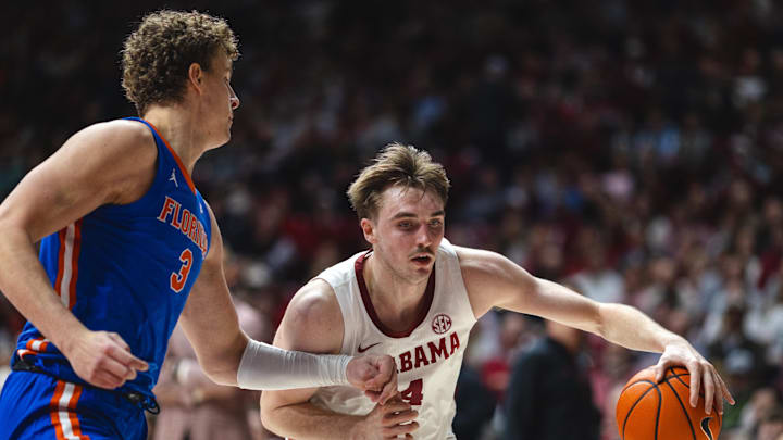 Mar 5, 2025; Tuscaloosa, Alabama, USA; Alabama Crimson Tide forward Grant Nelson (4) drives the ball against Florida Gators center Micah Handlogten (3) during the second half at Coleman Coliseum. Mandatory Credit: Will McLelland-Imagn Images