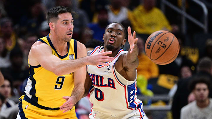 Oct 27, 2024; Indianapolis, Indiana, USA; Indiana Pacers guard T.J. McConnell (9) passes the ball around Philadelphia 76ers guard Tyrese Maxey (0) during the second half at Gainbridge Fieldhouse. Mandatory Credit: Marc Lebryk-Imagn Images