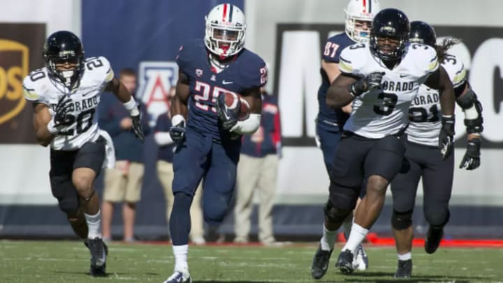 Ka'Deem Carey running for the end zone, leaving a crowd of Colorado defenders in his dust