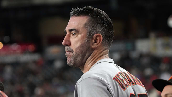A baseball player wearing a white uniform that says "Verlander" in orange, turned to the side. A baseball player wearing a white uniform that says "Verlander" in orange, turned to the side.