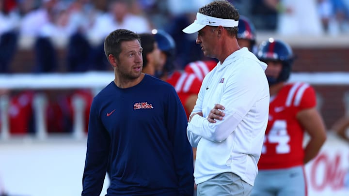 Aug 30, 2025; Oxford, Mississippi, USA; Mississippi Rebels head coach Lane Kiffin (right) talks with offensive coordinator Charlie Weis Jr. during warm ups prior to the game against the Georgia State Panthers at Vaught-Hemingway Stadium. Mandatory Credit: Petre Thomas-Imagn Images