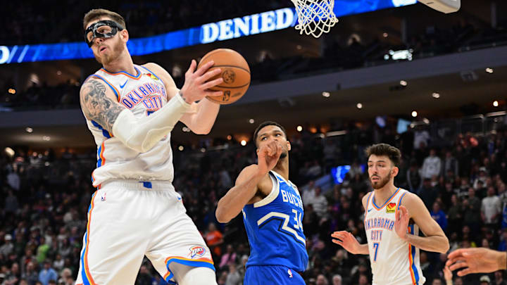 Mar 16, 2025; Milwaukee, Wisconsin, USA; Oklahoma City Thunder center Isaiah Hartenstein (55) grabs a rebound against Milwaukee Bucks forward Giannis Antetokounmpo (34) in the fourth quarter at Fiserv Forum. Mandatory Credit: Benny Sieu-Imagn Images