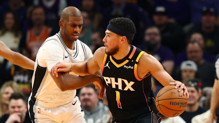 Dec 3, 2024; Phoenix, Arizona, USA; Phoenix Suns guard Devin Booker (1) against San Antonio Spurs guard Chris Paul (3) during an NBA Cup game at Footprint Center. Mandatory Credit: Mark J. Rebilas-Imagn Images