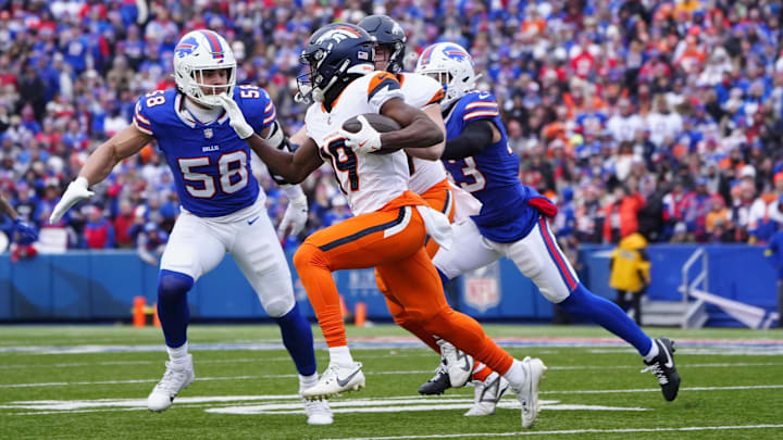 Jan 12, 2025; Orchard Park, New York, USA; Denver Broncos wide receiver Marvin Mims Jr. (19) runs for a gain as Buffalo Bills linebacker Matt Milano (58) defends.