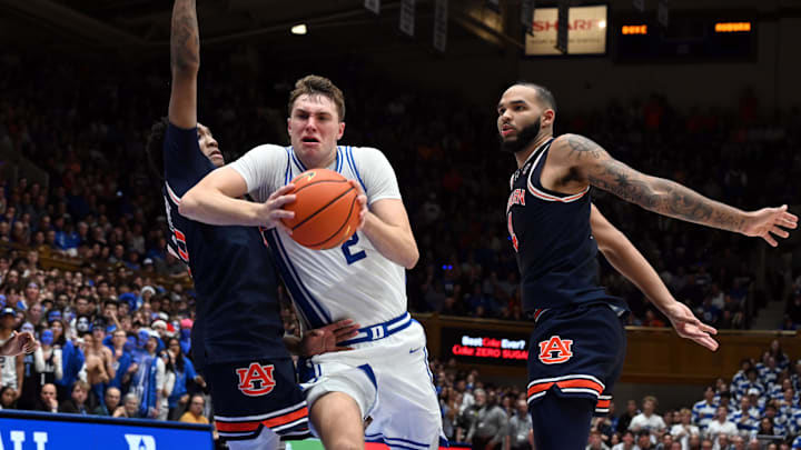 Dec 4, 2024; Durham, North Carolina, USA; Duke Blue Devils forward Cooper Flagg (2) drives to the basket between Auburn Tigers guard Tahaad Pettiford (0) and center Johni Broome (4) during the second half at Cameron Indoor Stadium. The Blue Devils won 84-78.   Mandatory Credit: Rob Kinnan-Imagn Images
