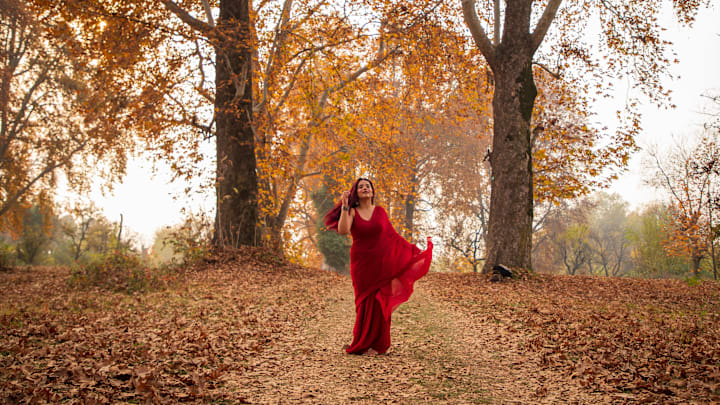 Indian tourist girl walks amid fallen leaves of Chinar trees...