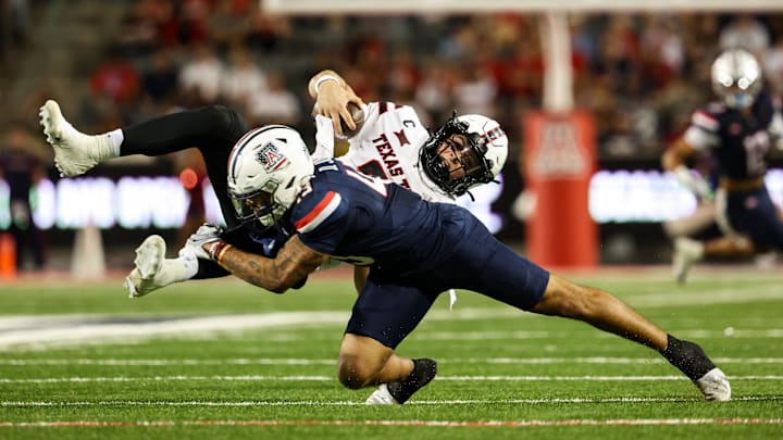 Oct 5, 2024; Tucson, Arizona, USA; Arizona Wildcats defensive back Dalton Johnson (43) tackles Texas Tech Red Raiders quarterback Behren Morton (2) during third quarter at Arizona Stadium. Mandatory Credit: Aryanna Frank-Imagn Images Oct 5, 2024; Tucson, Arizona, USA; Arizona Wildcats defensive back Dalton Johnson (43) tackles Texas Tech Red Raiders quarterback Behren Morton (2) during third quarter at Arizona Stadium. Mandatory Credit: Aryanna Frank-Imagn Images