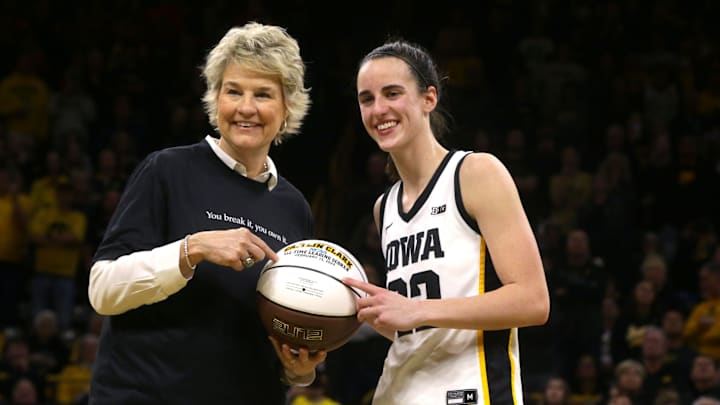 Iowa coach Lisa Bluder hands Caitlin Clark (22) a game ball commemorating her NCAA all-time scoring record Thursday, Feb. 15, 2024 at Carver-Hawkeye Arena in Iowa City, Iowa.