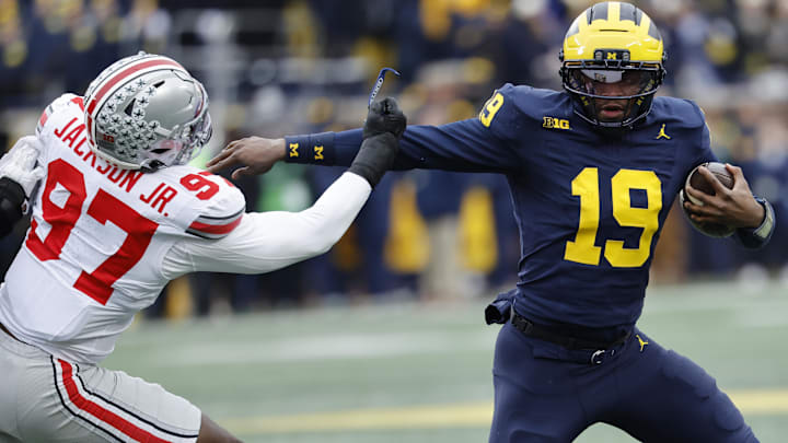Nov 29, 2025; Ann Arbor, Michigan, USA; Michigan Wolverines quarterback Bryce Underwood (19) runs the ball defended by Ohio State Buckeyes defensive end Kenyatta Jackson Jr. (97) in the first half at Michigan Stadium. Mandatory Credit: Rick Osentoski-Imagn Images Nov 29, 2025; Ann Arbor, Michigan, USA; Michigan Wolverines quarterback Bryce Underwood (19) runs the ball defended by Ohio State Buckeyes defensive end Kenyatta Jackson Jr. (97) in the first half at Michigan Stadium. Mandatory Credit: Rick Osentoski-Imagn Images