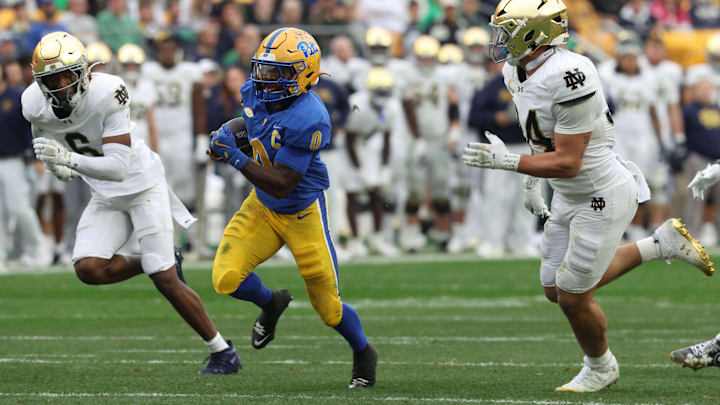 Nov 15, 2025; Pittsburgh, Pennsylvania, USA;  Pittsburgh Panthers running back Desmond Reid (0) runs the ball as Notre Dame Fighting Irish cornerback Christian Gray (6) and linebacker Drayk Bowen (34) chase during the third quarter at Acrisure Stadium. Mandatory Credit: Charles LeClaire-Imagn Images