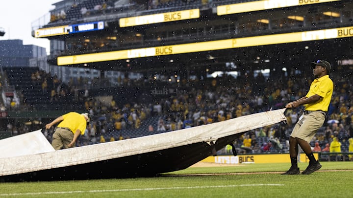 Jul 1, 2023; Pittsburgh, Pennsylvania, USA; The Pittsburgh Pirates grounds crew pulls the tarp onto the field  during a rain delay in the ninth inning against the Milwaukee Brewers at PNC Park. Mandatory Credit: Scott Galvin-USA TODAY Sports