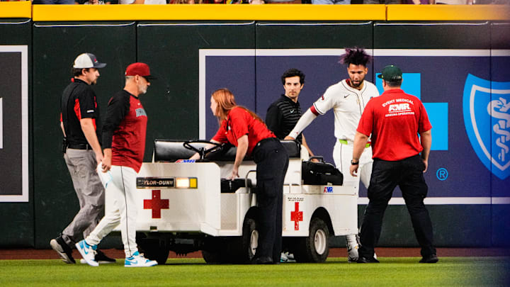 Sep 1, 2025; Phoenix, Arizona, USA; Arizona Diamondbacks outfielder Lourdes Gurriel Jr. (12) is loaded on a cart after colliding with Arizona Diamondbacks centerfielder Blaze Alexander (9) in the outfield in the sixth inning during the game between the Texas Rangers and Arizona Diamondbacks at Chase Field. Mandatory Credit: Arianna Grainey-Imagn Images