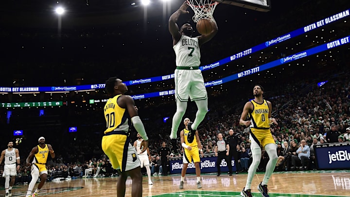 Dec 29, 2024; Boston, Massachusetts, USA: Boston Celtics guard Jaylen Brown (7) dunks the ball while Indiana Pacers guard Bennedict Mathurin (00) and guard Tyrese Haliburton (0) look on during the first half at TD Garden. Mandatory Credit: Bob DeChiara-Imagn Images