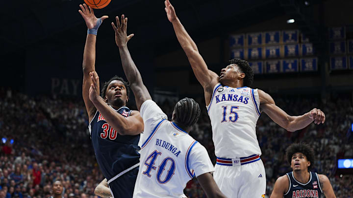 Feb 7, 2026; Lawrence, Kansas, USA; Arizona Wildcats forward Tobe Awaka (30) shoots against Kansas Jayhawks forward Flory Bidunga (40) and forward Bryson Tiller (15) during the first half at Allen Fieldhouse. Mandatory Credit: Jay Biggerstaff-Imagn Images