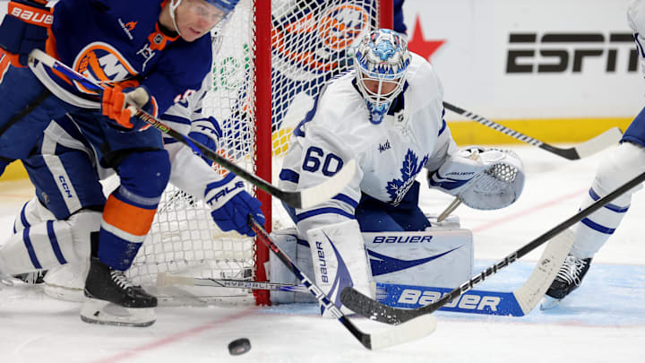 Jan 2, 2025; Elmont, New York, USA; Toronto Maple Leafs goaltender Joseph Woll (60) makes a save against New York Islanders center Casey Cizikas (53) during the second period at UBS Arena. Mandatory Credit: Brad Penner-Imagn Images