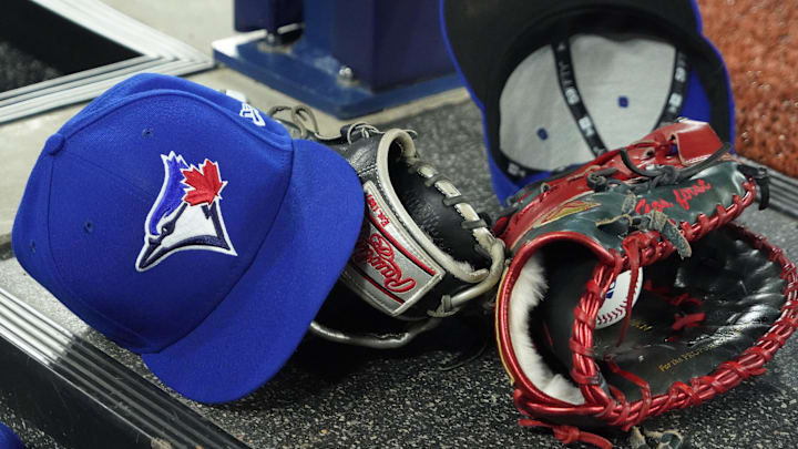 Apr 27, 2024; Toronto, Ontario, CAN; A pair of Toronto Blue Jays hats and gloves in the dugout during the first inning against the Los Angeles Dodgers at Rogers Centre. Mandatory Credit: John E. Sokolowski-Imagn Images