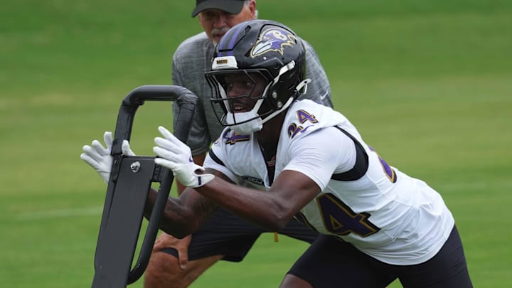 Jul 24, 2025; Owings Mills, MD, USA; Baltimore Ravens coach Chuck Pagano and safety Malaki Starks (24) work on drills during training camp at the Under Armour Performance Center. Mandatory Credit: Mitch Stringer-Imagn Images Jul 24, 2025; Owings Mills, MD, USA; Baltimore Ravens coach Chuck Pagano and safety Malaki Starks (24) work on drills during training camp at the Under Armour Performance Center. Mandatory Credit: Mitch Stringer-Imagn Images