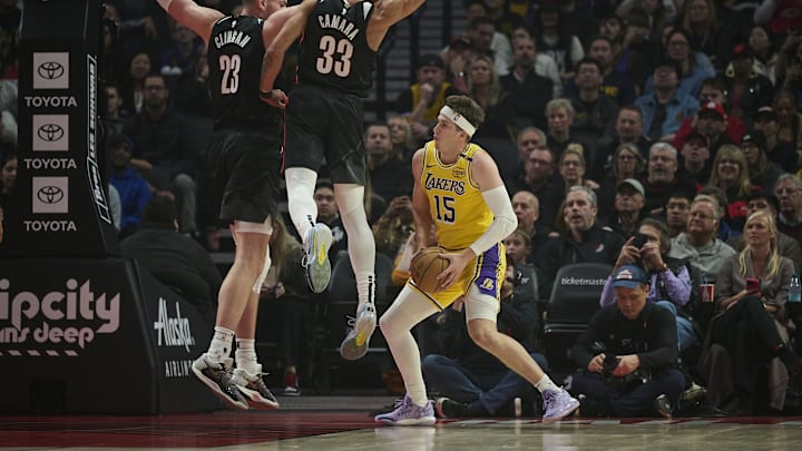 Feb 20, 2025; Portland, Oregon, USA; Los Angeles Lakers guard Austin Reaves (15) drives to the basket during the first half against Portland Trail Blazers center Donovan Clingan (23) and forward Toumani Camara (33) at Moda Center. Mandatory Credit: Troy Wayrynen-Imagn Images