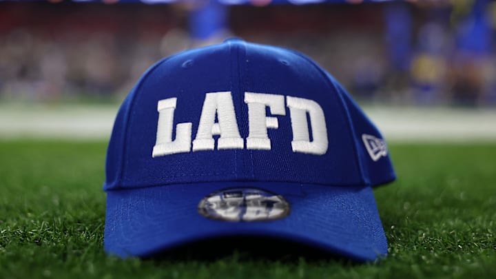 Jan 13, 2025; Glendale, AZ, USA; A football hat honoring the Los Angeles Fire Department  is displayed on the field before the NFC wild card game at State Farm Stadium. Mandatory Credit: Mark J. Rebilas-Imagn Images