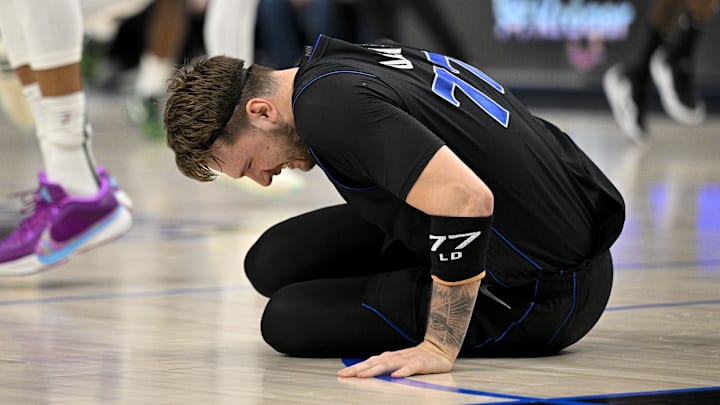 Feb 3, 2024; Dallas, Texas, USA; Dallas Mavericks guard Luka Doncic (77) appears to suffer a leg injury as he battles for the loose ball with Milwaukee Bucks forward Giannis Antetokounmpo (34) during the first quarter at the American Airlines Center. Mandatory Credit: Jerome Miron-Imagn Images