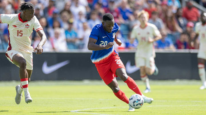 USMNT striker Folarin Balogun dribbles the ball against Canada.