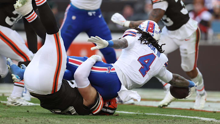 Dec 21, 2025; Cleveland, Ohio, USA;  Buffalo Bills running back James Cook III (4) scores a touchdown as Cleveland Browns linebacker Carson Schwesinger (49) defends during the first half at Huntington Bank Field.