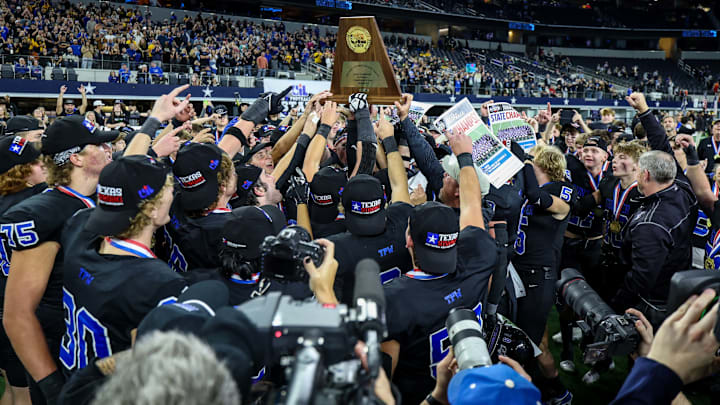 Gunter players hoist the trophy following their victory in the Texas 3A Division 2 state title game at AT&T Satdium.