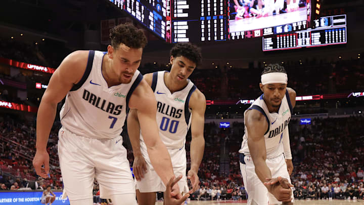 Mar 14, 2025; Houston, Texas, USA; Dallas Mavericks forward Naji Marshall (13) is helped off the floor by center Dwight Powell (7) and guard Max Christie (00) after being fouled by the Houston Rockets in the second half at Toyota Center. Mandatory Credit: Thomas Shea-Imagn Images