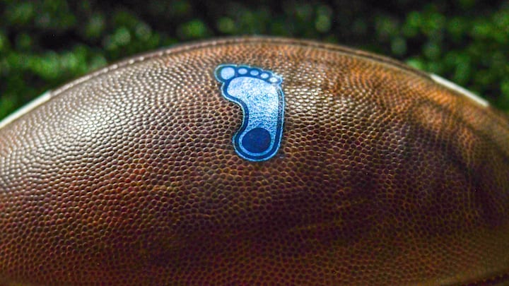 Oct 30, 2021; South Bend, Indiana, USA; A detail of the North Carolina Tar Heels logo on a football during the game against the Notre Dame Fighting Irish at Notre Dame Stadium. Mandatory Credit: Matt Cashore-Imagn Images Oct 30, 2021; South Bend, Indiana, USA; A detail of the North Carolina Tar Heels logo on a football during the game against the Notre Dame Fighting Irish at Notre Dame Stadium. Mandatory Credit: Matt Cashore-Imagn Images