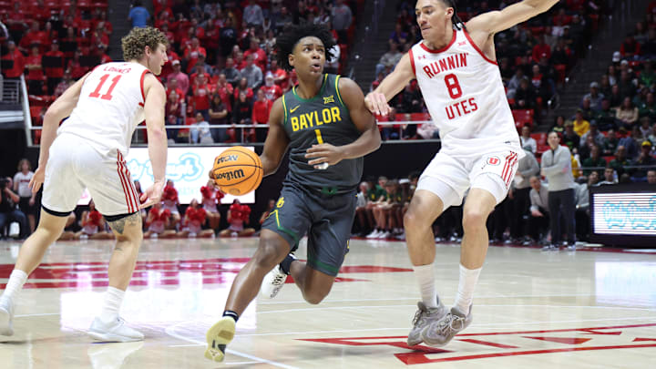 Jan 25, 2025; Salt Lake City, Utah, USA; Baylor Bears guard Robert Wright III (1) drives to the basket against Utah Utes forward Keanu Dawes (8) during the first half at Jon M. Huntsman Center. Mandatory Credit: Rob Gray-Imagn Images