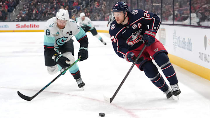 Blue Jackets forward Mathieu Olivier works against Kraken defenseman Adam Larsson.