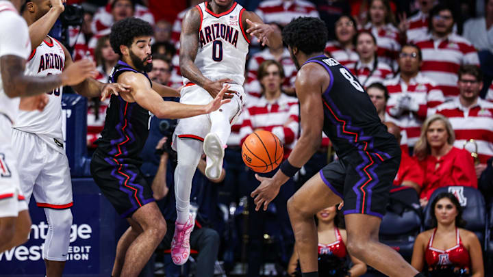 Dec 30, 2024; Tucson, Arizona, USA; Arizona Wildcats guard Jaden Bradley (0) loses control over the ball as TCU Horned Frogs guard Noah Reynolds (21) and TCU Horned Frogs center Ernest Udeh Jr. (8) attempt to grab the ball during the first half of the game at McKale Center. Mandatory Credit: Aryanna Frank-Imagn Images