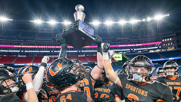 Uxbridge football captains hoist the state championship trophy after beating Mashpee at Gillette Stadium Wednesday.