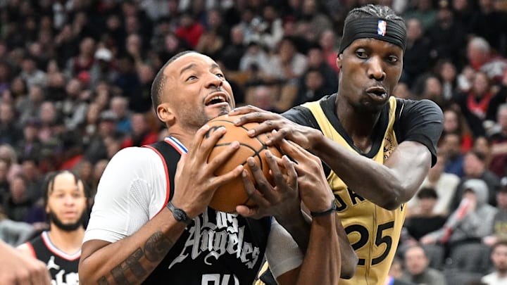 Jan 26, 2024; Toronto, Ontario, CAN;   Los Angeles Clippers guard Norman Powell 24) plays for the ball with Toronto Raptors forward Chris Boucher (25) in the second half at Scotiabank Arena. Mandatory Credit: Dan Hamilton-Imagn Images