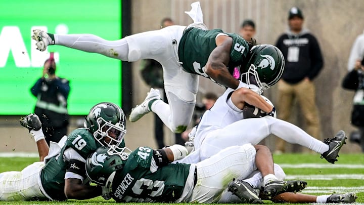 From left, Michigan State's Armorion Smith, Malik Spencer and Jordan Hall tackle Penn State's Trebor Pe–a during the first quarter on Saturday, Nov. 15, 2025, at Spartan Stadium in East Lansing.